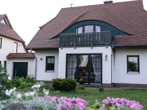 a white house with a deck on top of it at Borner Schlafwandler in Born