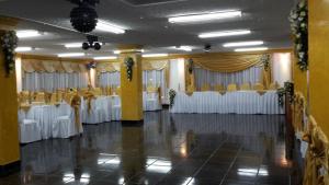a banquet hall with white tables and chairs at Hotel Espindola in Tulcán