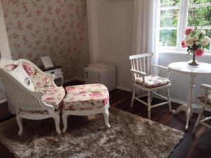 uma sala de estar com duas cadeiras e uma mesa em Chalé Boutique Blumenhof em Blumenau