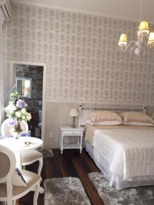 a bedroom with a bed and a table and chairs at Chalé Boutique Blumenhof in Blumenau