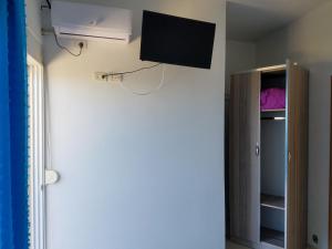 a flat screen tv hanging on the wall of a room at Sunset Hotel Roza in Vlorë