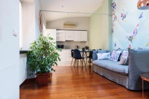 a living room with a blue couch and a kitchen at Lora Center apartment, near the lake with air conditioner in Como