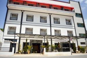グアラティンゲタにあるRohedama Hotelの赤い屋根の大きな白い建物