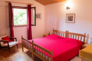 ein Schlafzimmer mit einem großen roten Bett und einem Fenster in der Unterkunft Apartments Lovor in Silba