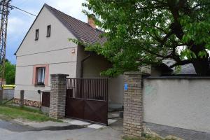 uma casa branca com um portão e uma cerca em U Lokálky em Zadní Třebaň