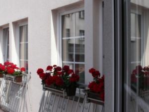 a window with red flowers on a balcony at Hotel Sukiennice in Chojnice