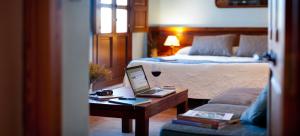una habitación de hotel con una cama y un ordenador portátil en una mesa en La Font D'Alcala, en Alcalá de la Jovada
