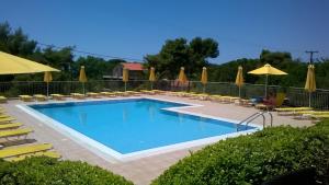 a swimming pool with chairs and umbrellas at Marinos Apartments in Lassi