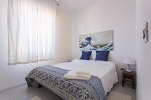 una camera da letto con letto e cuscini blu di Fiore Penthouse ad Alghero