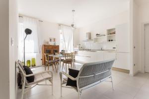 una cucina e una sala da pranzo con tavolo e sedie di Fiore Penthouse ad Alghero