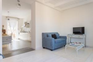 un soggiorno con sedia blu e TV di Fiore Penthouse ad Alghero