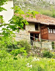 una antigua casa de piedra con una ventana y una puerta en Sol de Asturias, en Cazo