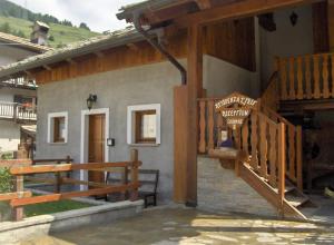 a house with a wooden staircase and a porch at Residenza L'Teit in Sestriere