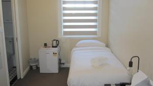 une chambre à l'hôpital avec un lit et une fenêtre dans l'établissement Katoomba Hotel, à Katoomba