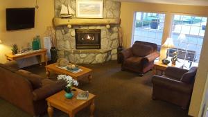 una sala de estar con sofás y una chimenea de piedra. en Baymont by Wyndham Coeur D Alene en Coeur d'Alene