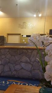 a bathroom with a mirror and a vase of flowers at Baymont by Wyndham Coeur D Alene in Coeur d'Alene