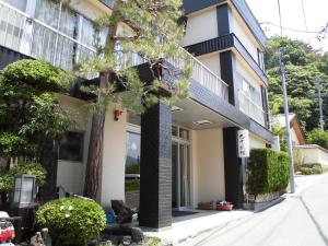 una casa con un gato sentado frente a ella en Marunaka Ryokan, en Matsumoto