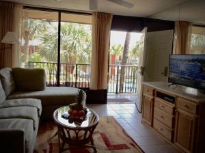 a living room with a couch and a tv and a table at Magic Tree Resort in Orlando