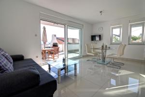 ein Wohnzimmer mit einem Sofa und einem Tisch in der Unterkunft Apartments Maris Senj in Senj