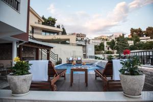 a patio with chairs and a table and a pool at Villa Premier in Ulcinj