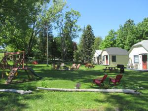 a yard with a playground with chairs and a swing at Cabines Boréales in Rimouski
