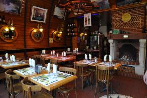 a restaurant with wooden tables and chairs and a fireplace at L'Escale in Étretat