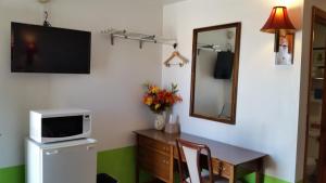 a room with a desk with a microwave and a tv at American Inn Motel Canon City in Canon City