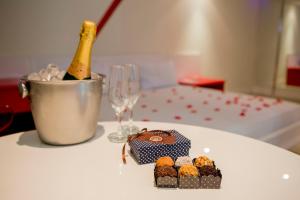 - une table avec une bouteille de champagne et quelques petits gâteaux dans l'établissement Rivieras Motel (Adult Only), à Santos