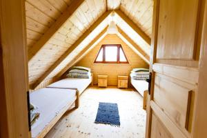 Zimmer im Dachgeschoss mit 2 Betten und einem Fenster in der Unterkunft Domki u Bronki in Grywałd
