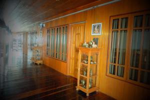 Habitación con paredes de madera, suelo de madera y estante. en The history cafe' & guesthouse en Sukhothai