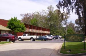 un estacionamiento con autos estacionados frente a un edificio en Corowa Golf Club Motel, en Corowa