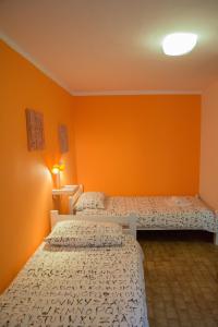 2 camas en una habitación con paredes de color naranja en Terra Apartments en Piran