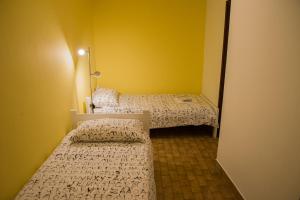 two beds in a small room with yellow walls at Terra Apartments in Piran