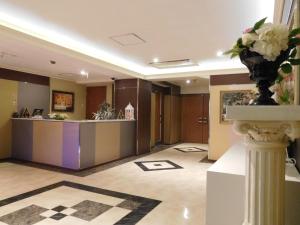 a lobby with a reception desk and a vase of flowers at AURA Resort Iga (Adult Only) in Iga