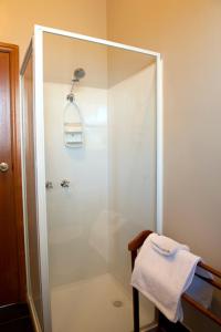 ducha con puerta de cristal y toalla en Webster Apartment en Ballarat