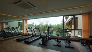 a gym with cardio machines and a large window at Aqua Resort SHA Plus in Rawai Beach