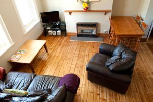 sala de estar con sofá de cuero y mesa en Webster Apartment en Ballarat