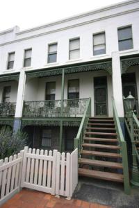 Una casa blanca con escaleras y una valla delante. en Webster Apartment en Ballarat