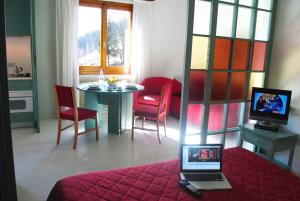 a room with a table and a laptop on a bed at Residence Antares in Madonna di Campiglio