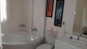 a bathroom with a tub and a toilet and a sink at The Guest House Pongola in Pongola
