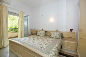 sypialnia z dużym łóżkiem i oknem w obiekcie Chita's House w mieście Paralia Vrachou