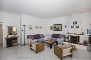 sala de estar con 2 sofás y chimenea en Chita's House, en Paralia Vrachou