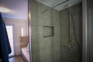 a shower with a glass door in a bathroom at Hotel Landgasthof Franz in Kreuzwertheim