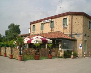 un edificio con una sombrilla delante de él en Hotel Regina, en Campolongo Maggiore