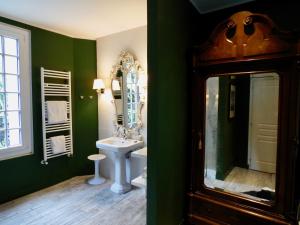 a green bathroom with a sink and a mirror at Bed & Breakfast La Clepsydre in Fontenay-aux-Roses