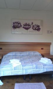 Una cama en una habitación de hotel con toallas. en Hotel Regina, en Campolongo Maggiore