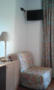 a room with a chair and a lamp on a table at Hotel Regina in Campolongo Maggiore
