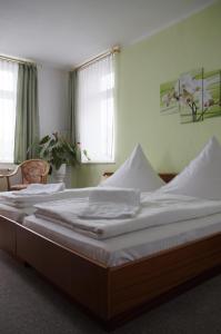 a bedroom with a large bed with white sheets at Ratskeller Thum in Thum