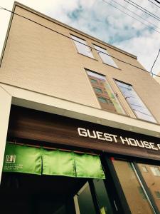 a store front with a guest house sign on it at Guest House On My Way in Sapporo