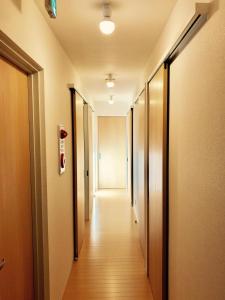 a corridor of an office with a long hallway at Guest House On My Way in Sapporo